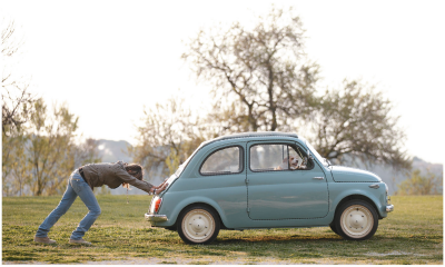 Person strains to push a car