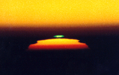 Green flash only rarely seen at sunset is caused by a competition between dispersive refraction and scattering in the atmosphere